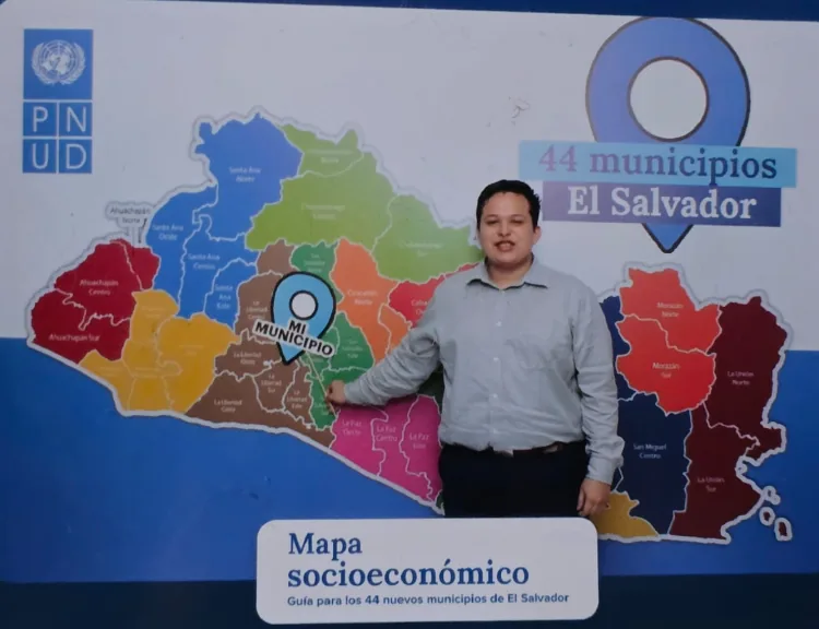 Martín Velasco frente al mapa socioeconómico de los 44 municipios de El Salvador